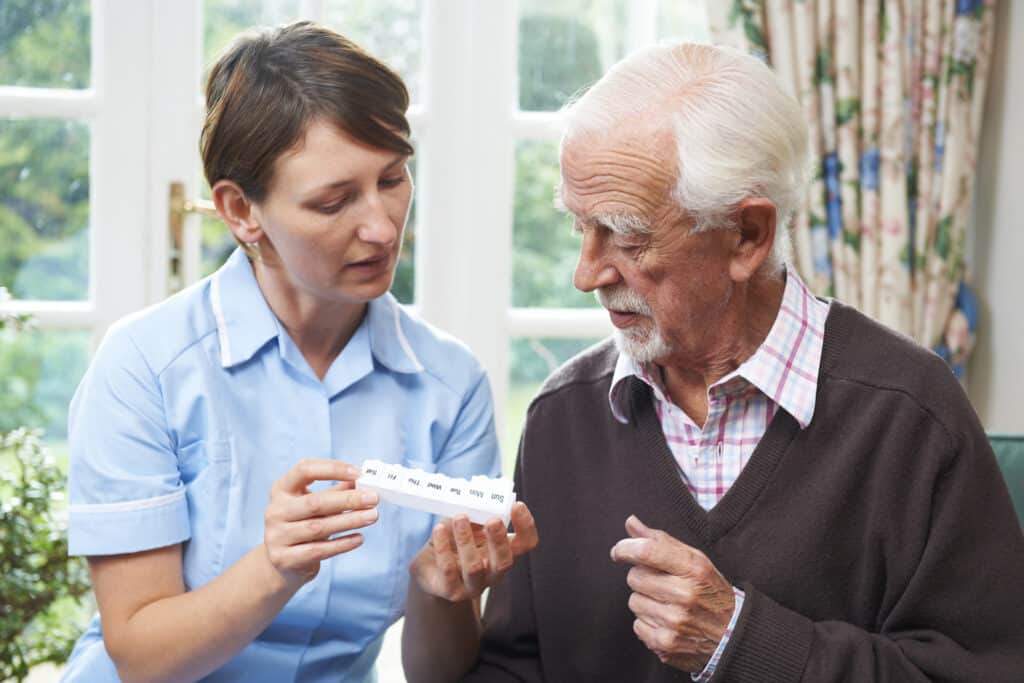 nurse showing senior male medication