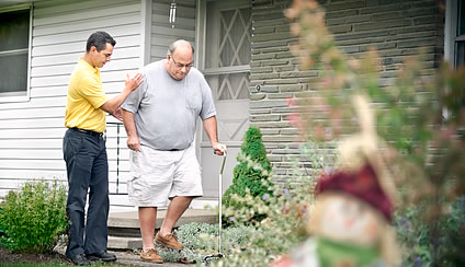 Male caregiver helping patient outside