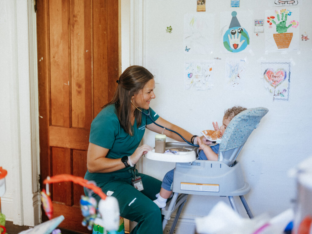 Home care nurse assisting child patient in a home setting